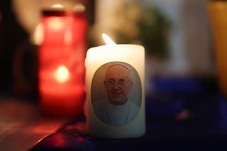 A candle with a picture of Pope Francis is placed at a makeshift memorial, near St Peter's Square, following the death of the pontiff, as seen from Rome, Italy, 23 April 2025